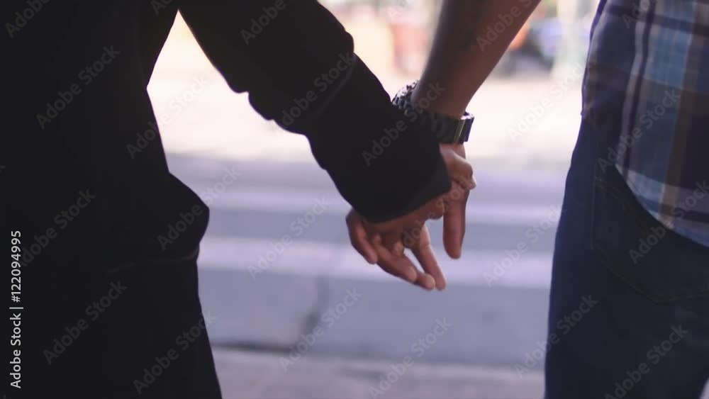 African American couple holding hands and walking, close up on their hands