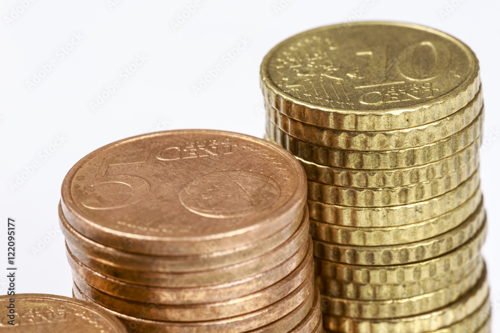 Close-up of different eurocent coins stacked in columns, on white. Close-up of different eurocent coins stacked in columns, on white.