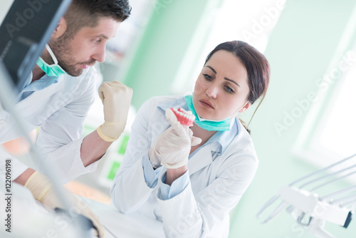 Dental prosthesis, dentures, prosthetics work. Dental students while working on the denture, false teeth, a study and a table with dental tools.