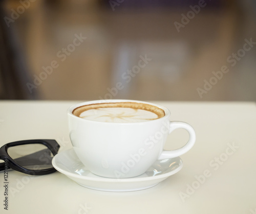 Fototapeta Naklejka Na Ścianę i Meble -  Coffee cup with glasses on wooden table ,soft focus