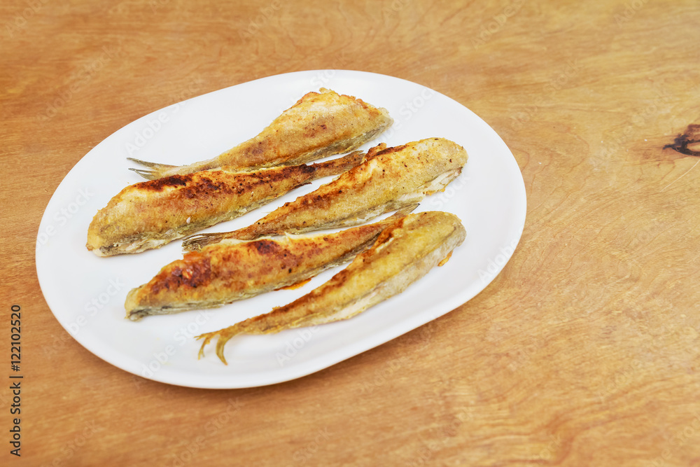 fish smelt fried in a plate. top view