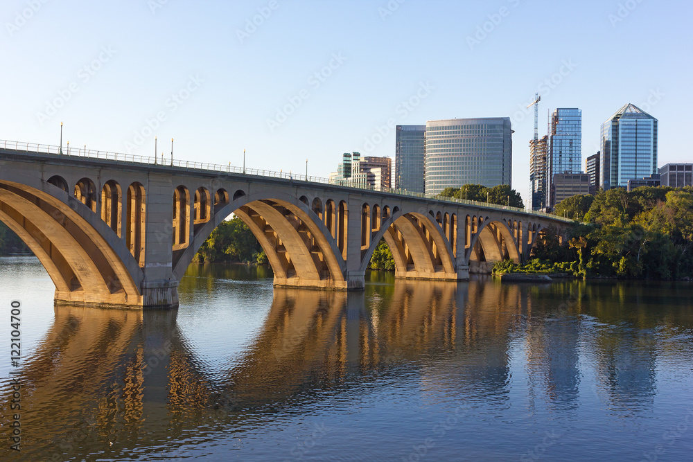 Key Bridge over Potomac River in early morning, Washington DC, USA. Bridge and buildings reflection in a quiet waters of the river.