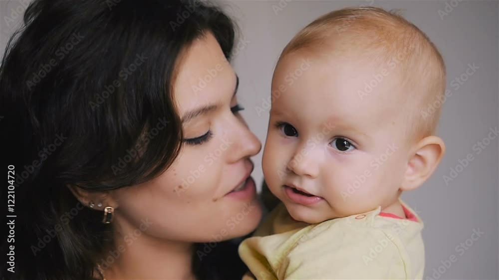 Young Happy Mother Holding her Newborn Child. Family at home. Beautiful smiling Mom and Happy Baby Together. Young Happy Mother Holding her Newborn Child. Family at home. Beautiful smiling Mom and Happy Baby Together.