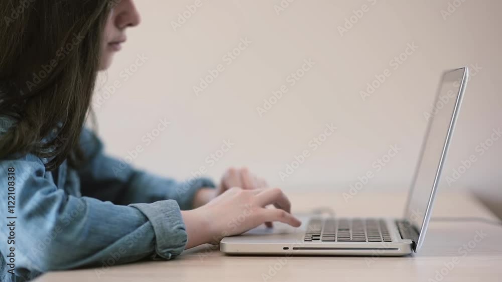 Teenage girls using a laptop sitting at table at home Teenage girls using a laptop sitting at table at home