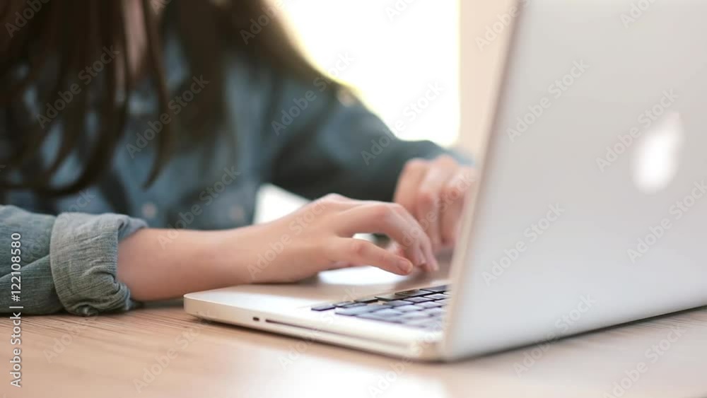 Teenage girls using a laptop sitting at table at home Teenage girls using a laptop sitting at table at home