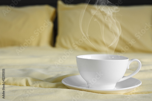 hot coffee and smoke in white cup on bed