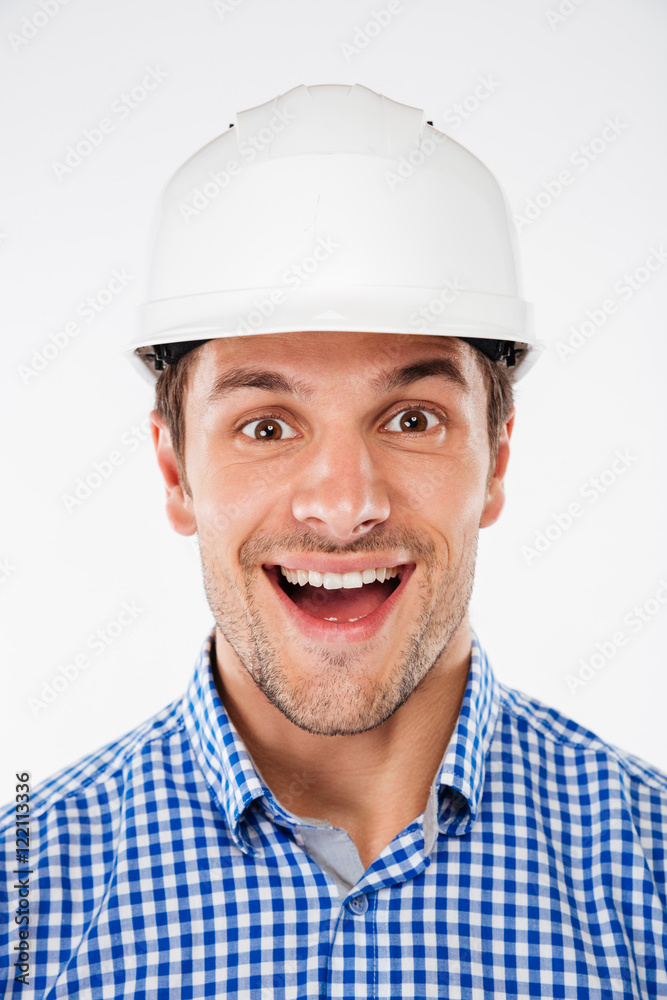 Portrait of cheerful excited young man architect in hard hat Portrait of cheerful excited young man architect in hard hat