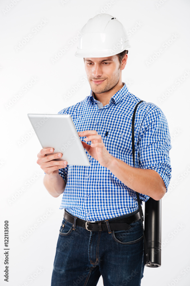 Man building engineer in hard hat standing and using tablet Man building engineer in hard hat standing and using tablet