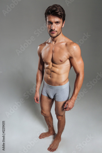 Portrait of a serious handsome muscular man in underwear standing