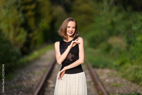 Elegant woman standing on railroad tracks
