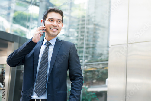 Attractive asian businessman talking on cellphone