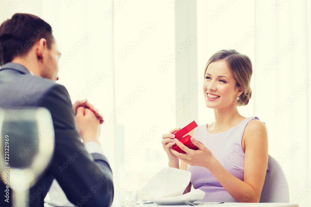 excited young woman looking at boyfriend with box excited young woman looking at boyfriend with box