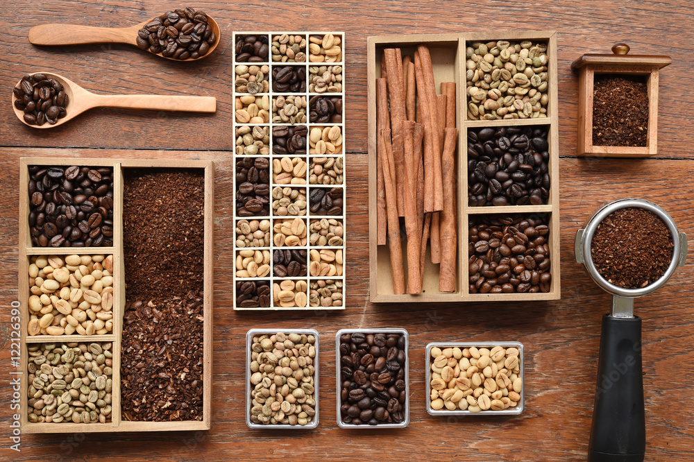 Coffee beans with ground coffee in wooden spoon and cinnamon on wooden background Coffee beans with ground coffee in wooden spoon and cinnamon on wooden background