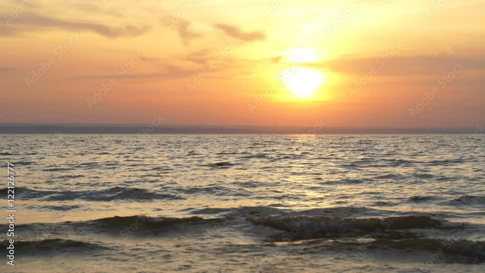 Shiny sea waves on the beach sand in sunset light Shiny sea waves on the beach sand in sunset light