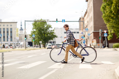 Fotografia young man with fixed gear bicycle on crosswalk