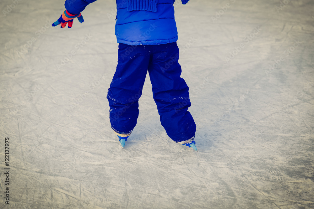 child feet learning to skate on ice in winter child feet learning to skate on ice in winter