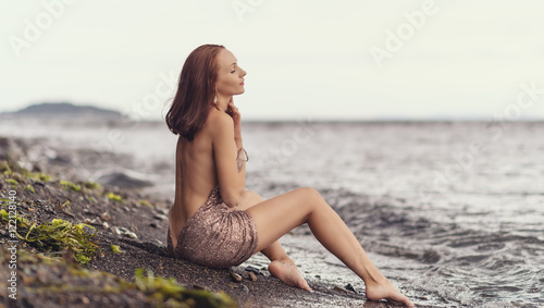 Beautiful woman in a dress on a beach.