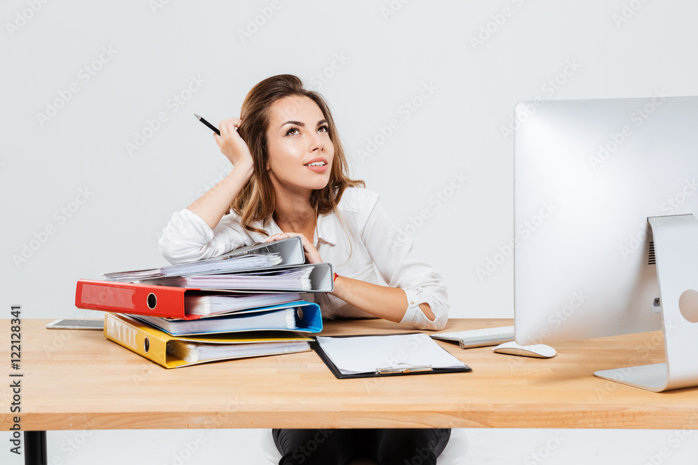 Portrait of pensive businesswoman thinking about something holding pen isoltaed