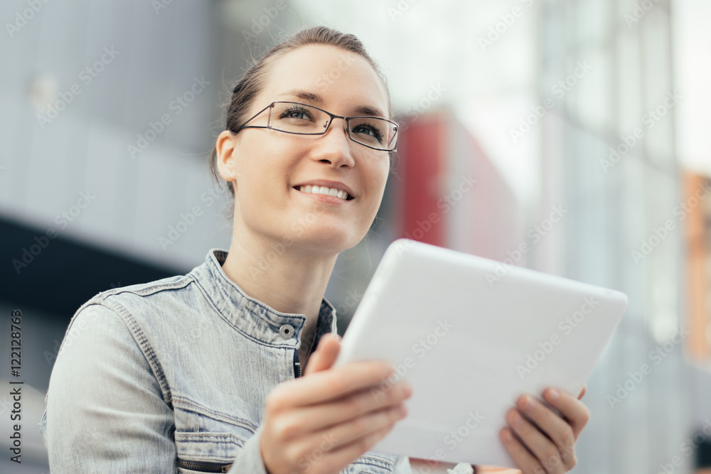 Young woman using tablet computer outdoor in a city Young woman using tablet computer outdoor in a city