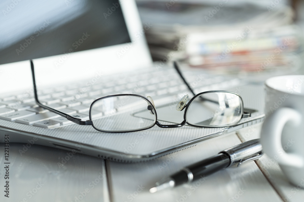Eyeglasses on laptop and coffee Eyeglasses on laptop and coffee