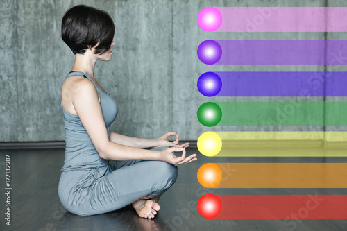 Woman practicing meditation with the chakras. Beautiful young woman doing yoga meditation in lotus posture with the activation of the chakras on the body