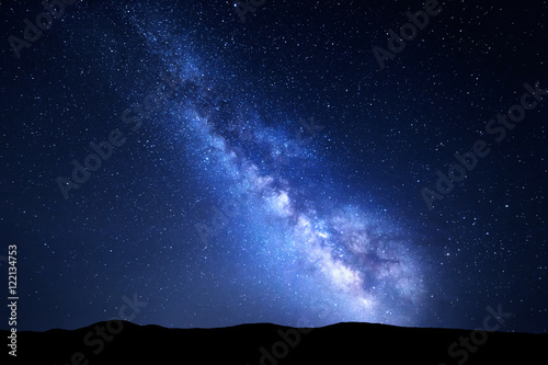Milky Way. Night colorful landscape with stars. Starry sky with hills at summer. Space background with galaxy at mountains. Nature background with blue milky way. Universe