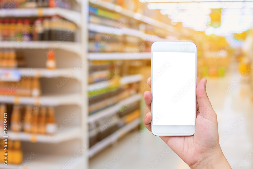 female hand holding mobile smartphone over supermarket backgroun female hand holding mobile smartphone over supermarket backgroun