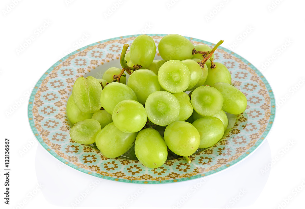 Seedless green grapes on a plate isolated on white background Seedless green grapes on a plate isolated on white background