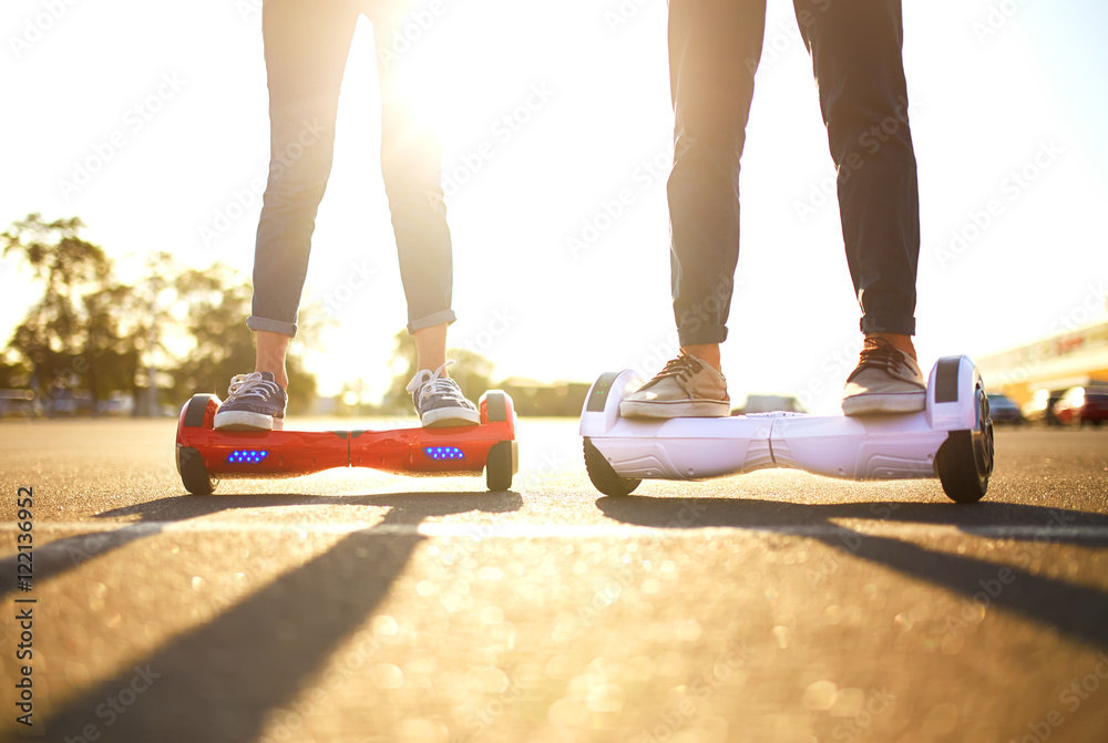 young man and woman riding on the Hoverboard in the park. content  technologies. a new movement. Close Up of Dual Wheel Self Balancing  Electric Skateboard Smart Stock Photo | Adobe Stock