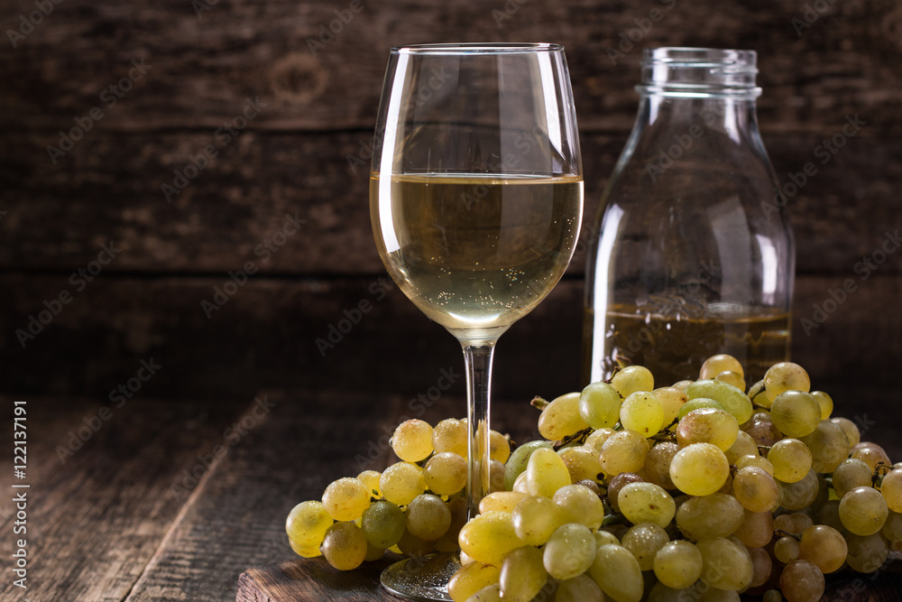 White wine and grapes.Wine and grapes on vintage wooden table White wine and grapes.Wine and grapes on vintage wooden table