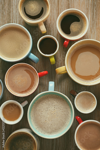 Cups of coffee on wooden background, top view