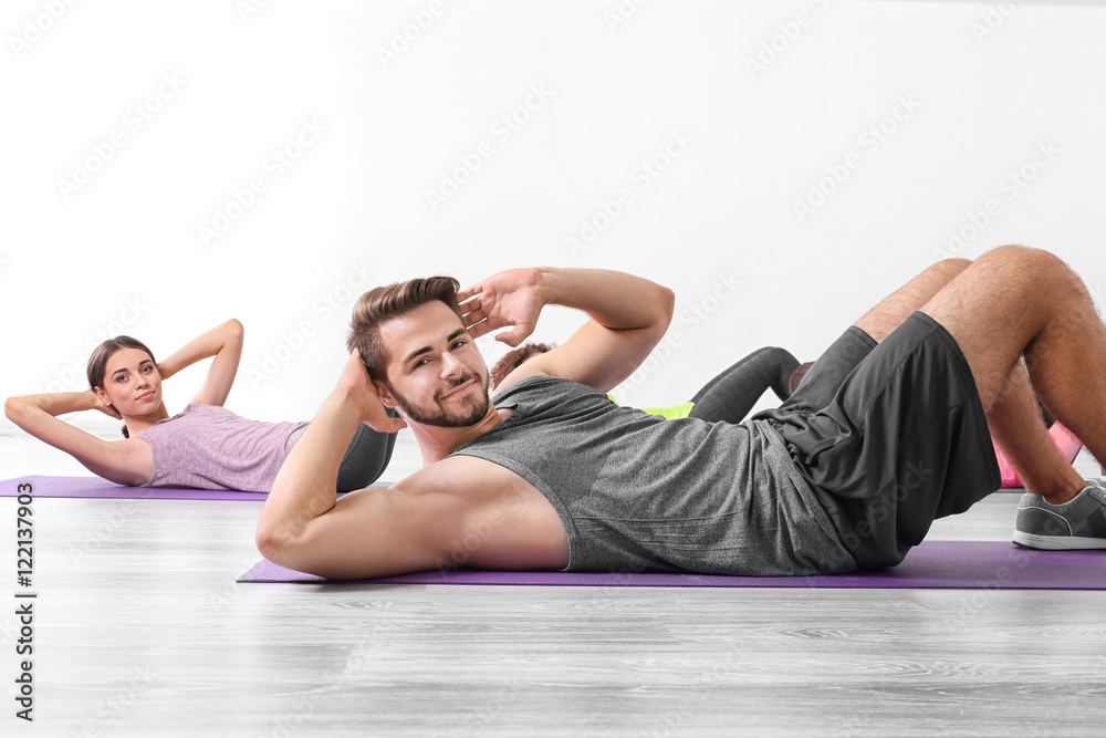 Obraz premium Group of people doing yoga exercises in gym