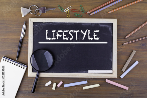 Lifestyle. Text on the chalk board. Wooden table with a magnifyi photo