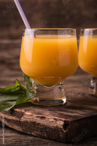 Citrus juice and fruits on wooden background.