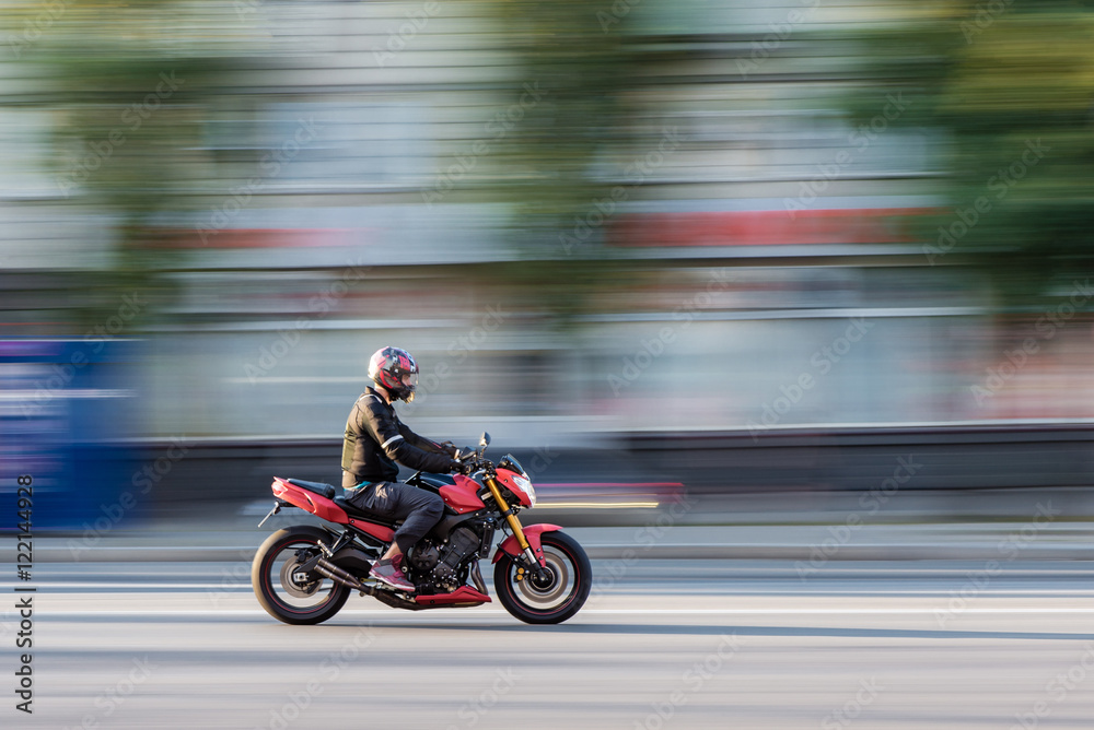 Motorcycle rider in the city traffic in motion blur