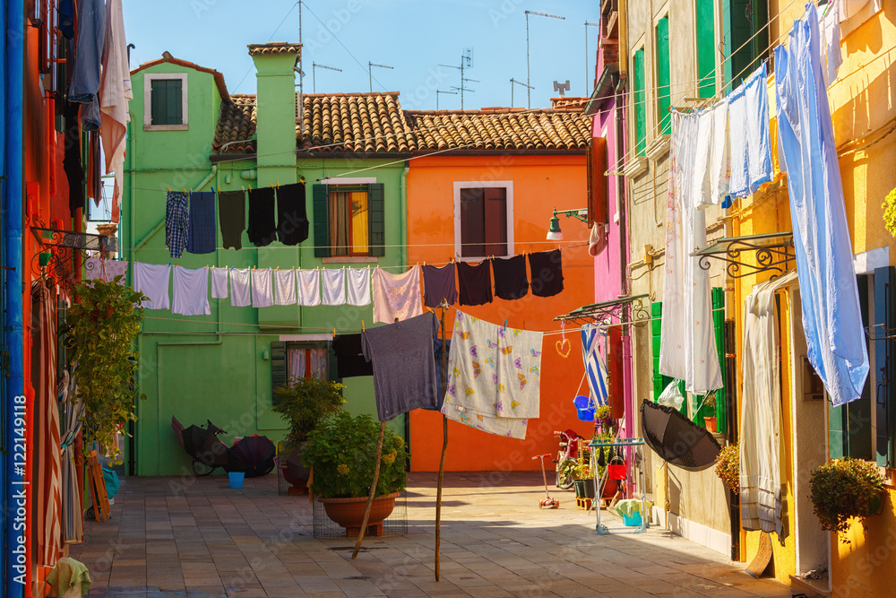 Obraz premium Exterior of colorful houses of Burano Island in Venice.Windows,walls,laundries,flowers and even umbrellas reflects the culture of the people in the island.