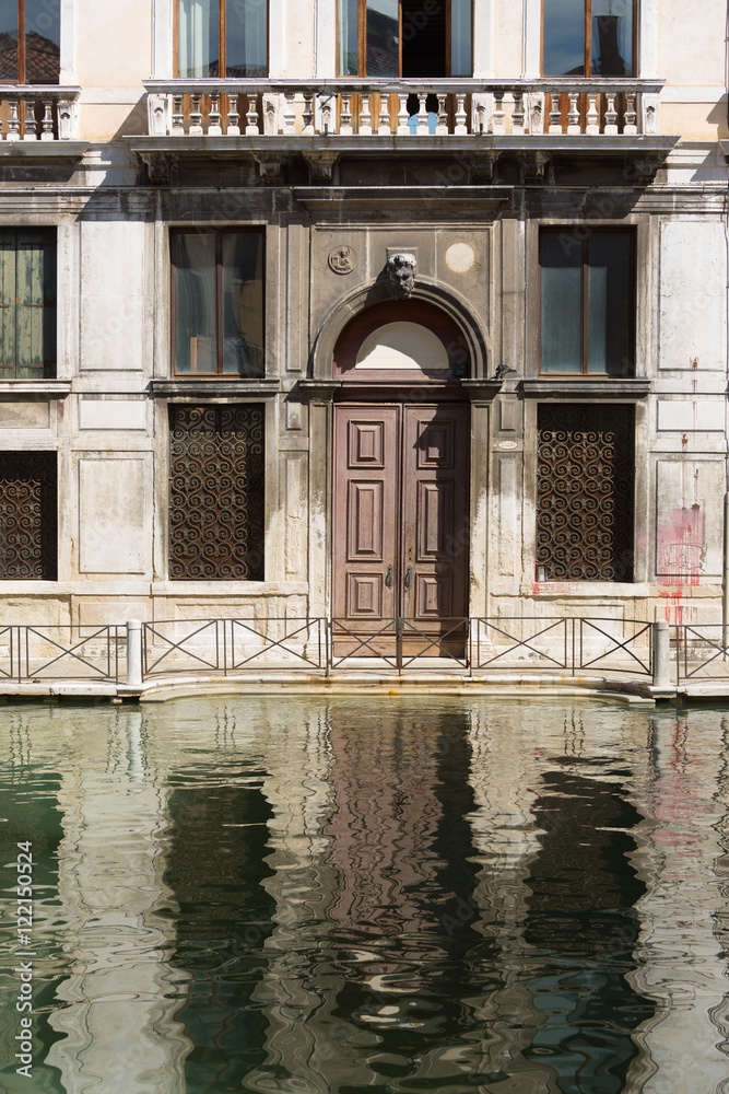 Facade of an old building and its reflection on water in Venice Facade of an old building and its reflection on water in Venice
