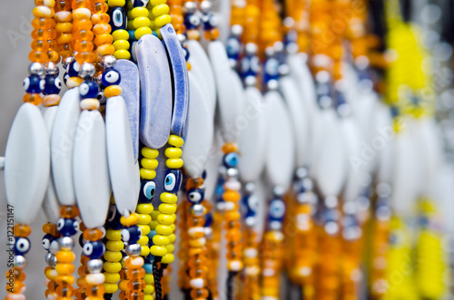 Amulet against the evil eye Nazar bondzhuk on bracelets of orange and yellow beads photo