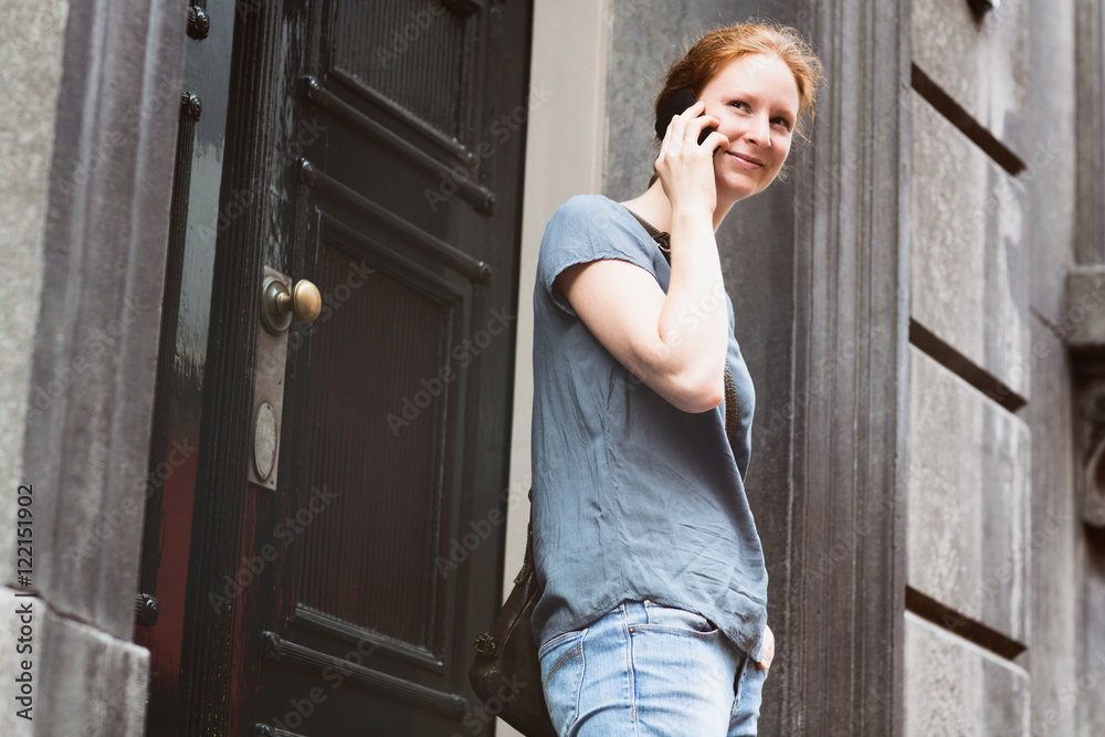 Fototapeta premium Woman on the Phone before a Building