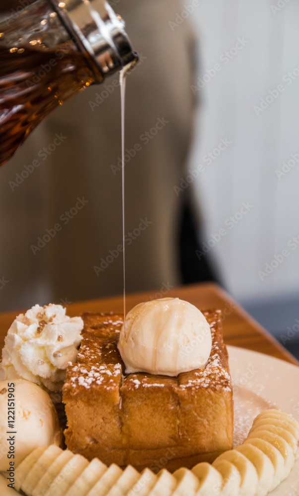 delicious dessert made of toast, icecream, banana top of honey syrup