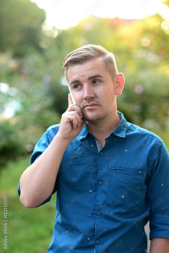 Obraz premium Young handsome hipster talking on the cellphone