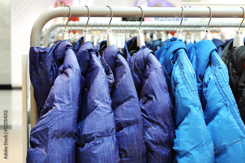 Clothes on hangers in shop. Jackets