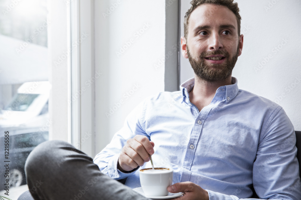 Young man with cup of coffee at the window Young man with cup of coffee at the window