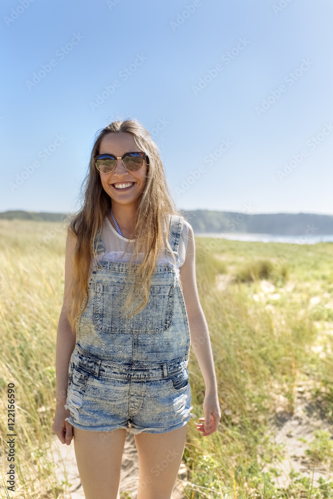Portrait of smiling teenage girl wearing dungarees on the beach Portrait of smiling teenage girl wearing dungarees on the beach