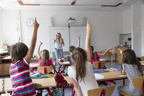 Active pupils raising their hands in class