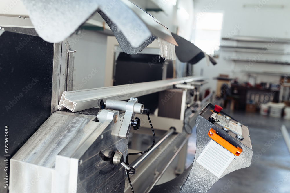 Close up shot of modern machine for aluminium and PVC profile cutting. Industrial indoors.