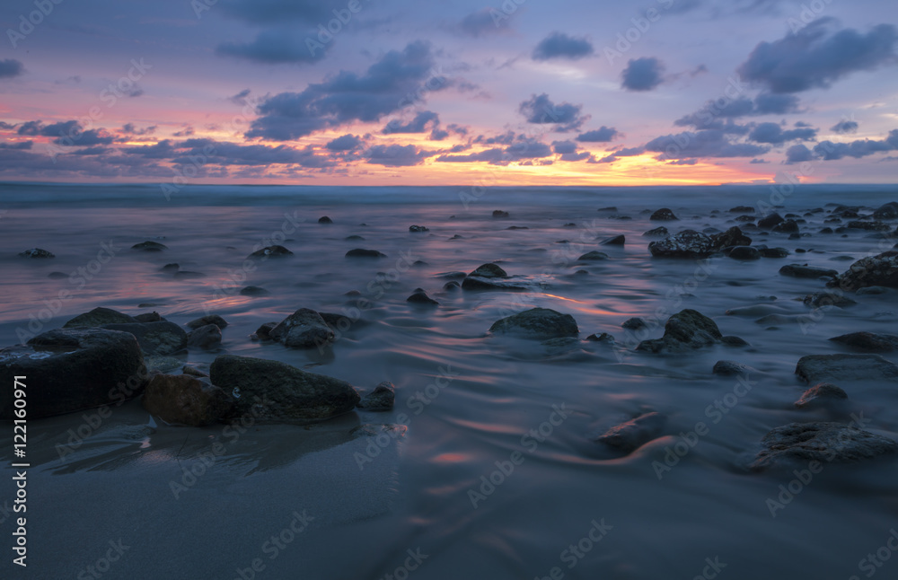 Ocean in motion/Ocean moving over rocks at sunset