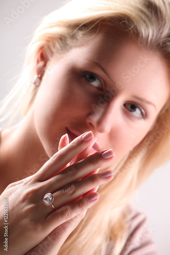 Beautiful young blonde shows off jewelry ring with stone