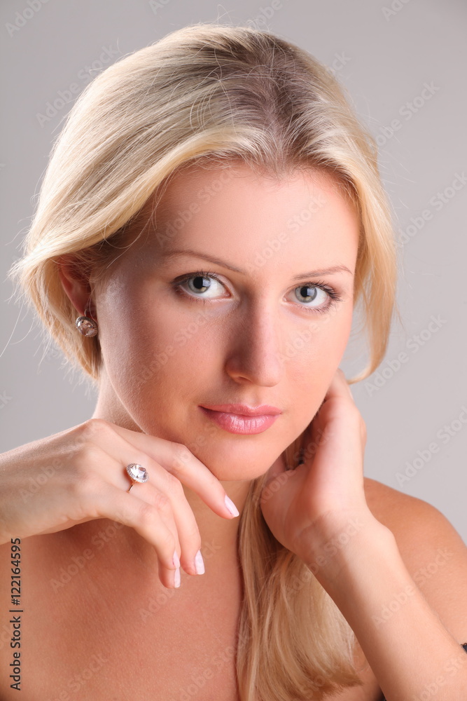 Fototapeta premium Beautiful young blonde shows off jewelry ring with stone