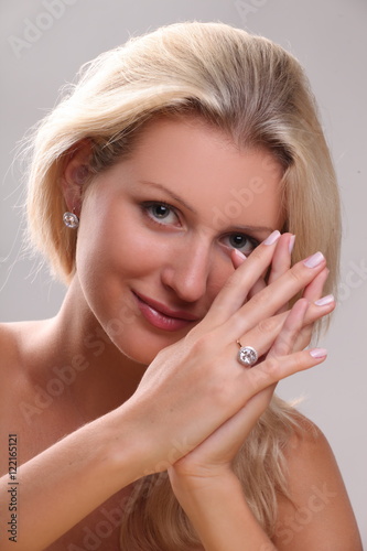 Beautiful young blonde shows off jewelry ring with stone